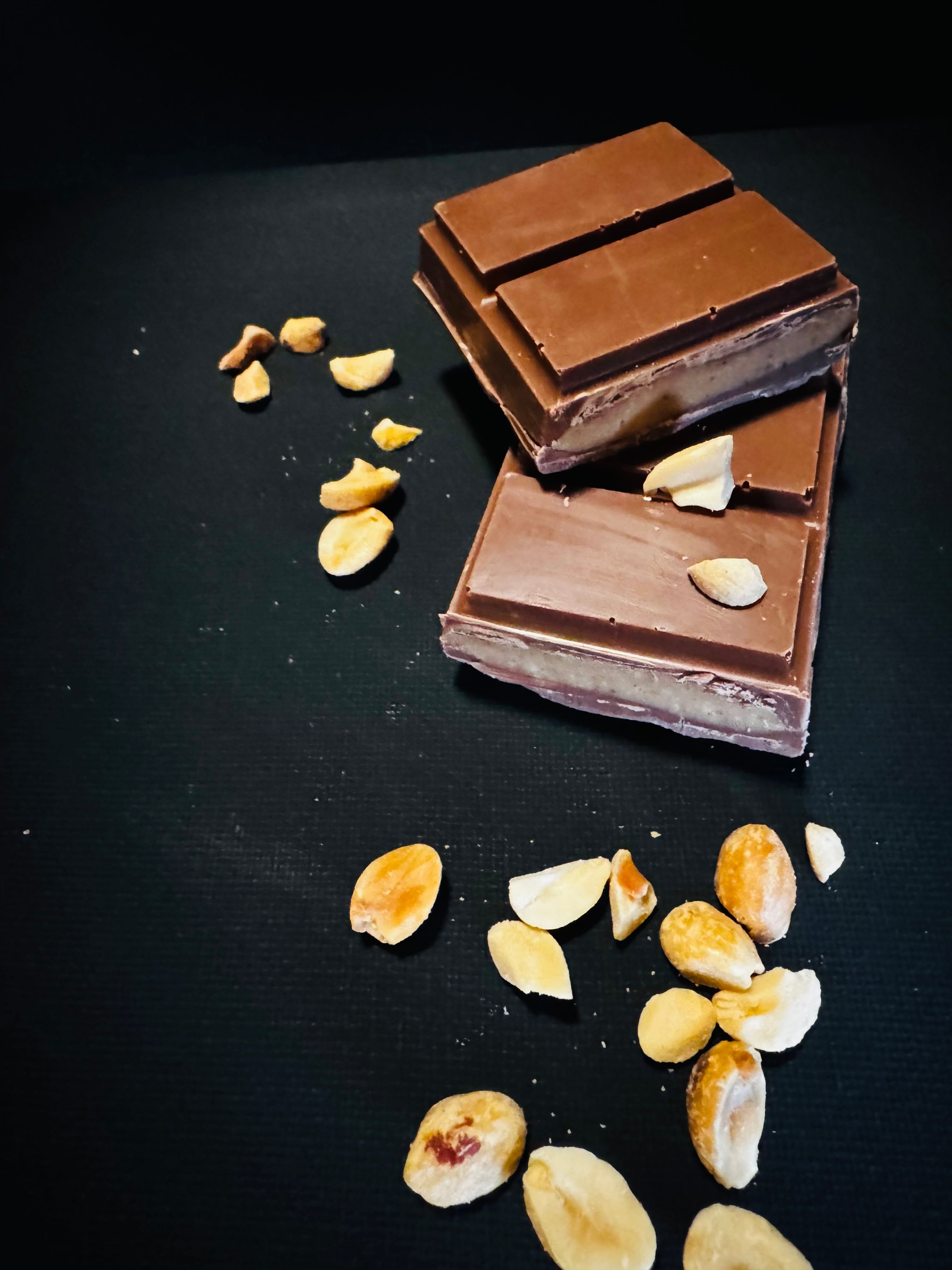 Chocolate bars with peanuts on a black background